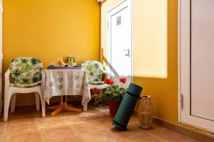 a dining room with a table and chairs and a yellow wall at Savoa Sea 365 in Tarajalejo +9 photos