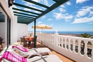 balcón con mesa, sillas y sombrilla en La Vega de Lanzarote 4, en Tías