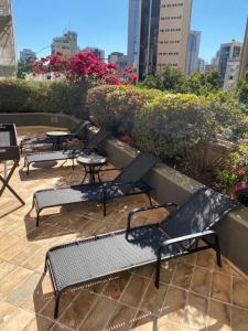 une rangée de chaises et de tables sur une terrasse dans une ville dans l'établissement Condomínio Max Savassi Superior apto 1302, à Belo Horizonte