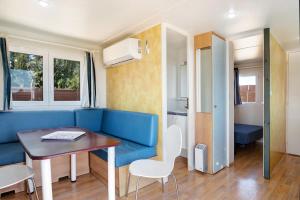 ein Wohnzimmer mit einem blauen Sofa und einem Tisch in der Unterkunft Eloy Playa 3 - Sólo Familias in Roche