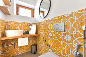ein Badezimmer mit orangefarbenen und weißen Wandfliesen in der Unterkunft Villa Fantagali apt 504 in Marina di Campo