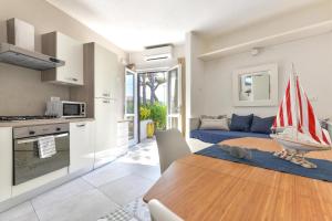 eine Küche und ein Wohnzimmer mit einem Holztisch mit einem Boot darauf in der Unterkunft Villa Fantagali apt 504 in Marina di Campo