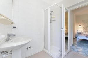 a white bathroom with a sink and a shower at La Galatea apt Libeccio in Marina di Campo