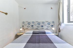 a bedroom with a bed with a blue and white bedspread at Villa Fantagali apt 501 in Marina di Campo