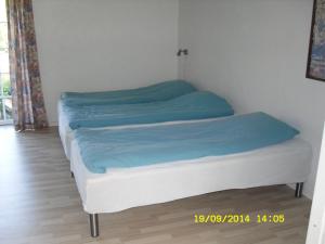 Una cama con sábanas azules en una habitación en Hellesvang, en Guderup 10 fotos más