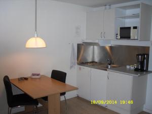 a small kitchen with a wooden table and a sink at Hellesvang in Guderup