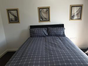 Early Knights at Huddersfield في هدرسفيلد: سرير في غرفة نوم مع صورتين على الحائط