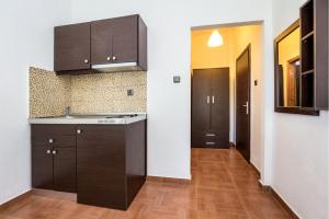 a kitchen with brown cabinets and a wooden floor at Androni in Potos