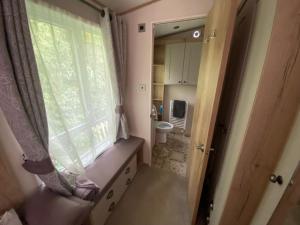a small bathroom with a window and a toilet at Starling Six Berth caravan in Alford