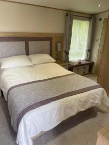 a bedroom with a large bed and a window at Starling Six Berth caravan in Alford