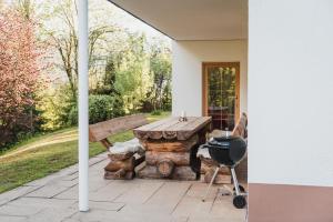 a grill and a picnic table on a patio at Ferienwohnung Waldgarten in Leiten