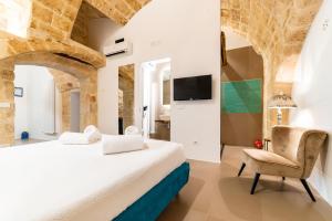 1 dormitorio con 1 cama y 1 silla en B&B A C-Caste, en Monopoli