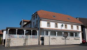 un grand bâtiment blanc avec un toit rouge dans l'établissement Hôtel Bellavista "Bellevue", à Saignelégier