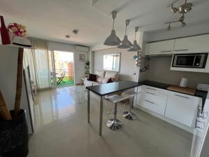 cocina con mesa y sala de estar en Apartamento Carihuela Torremolinos, en Torremolinos
