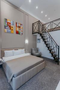 a bedroom with a large bed and a staircase at Callisto Hotel in Baku