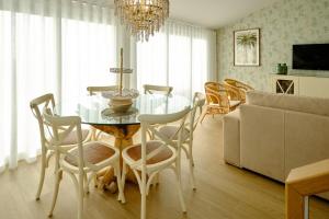 a dining room with a glass table and chairs at Resort Holidays Nazaré in Nazaré