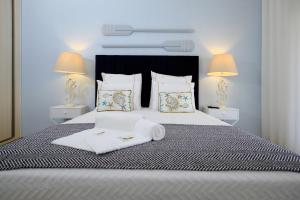 a bedroom with a bed with two towels on it at Resort Holidays Nazaré in Nazaré