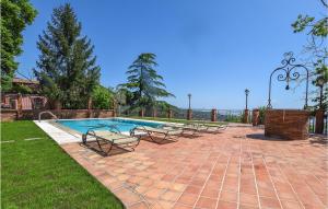 a swimming pool with lounge chairs next to at Cozy Home In Zafferana Etnea With Wifi in Zafferana Etnea