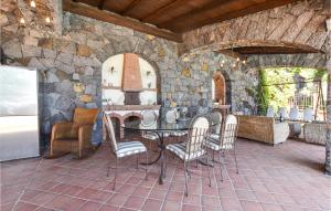 a patio with a table and chairs in a stone building at Cozy Home In Zafferana Etnea With Wifi in Zafferana Etnea