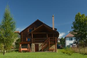 une grande cabane en rondins avec une véranda et une terrasse. dans l'établissement TRINITY Log Cabin Wellness resort, à Štrba