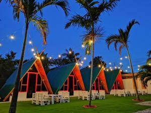 a building with chairs and palm trees in front of it at Glamping Alona in Panglao Island