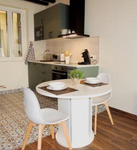 a kitchen with a table and chairs in a kitchen at Studio tout confort à 2 pas du Château st Germain in Saint-Germain-en-Laye