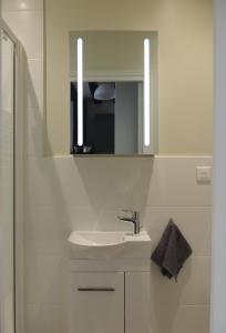 a white bathroom with a sink and a mirror at Studio tout confort à 2 pas du Château st Germain in Saint-Germain-en-Laye