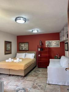 a bedroom with two beds and a red wall at Casa Sophia in Karavostamo