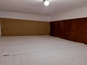 a bedroom with a large white bed with a wooden headboard at 20 Bakancs Apartman in Esztergom