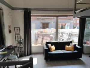 a living room with a couch and a large window at Gite la Denteliere in Calais