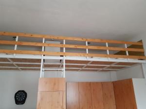 Łóżko na poddaszu w pokoju z drewnianymi belkami stropowymi w obiekcie 20 Bakancs Apartman w mieście Ostrzyhom +2 zdjęcia