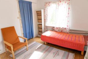 a room with a bed and a chair and a window at Cozy Home in Ydrefors in Ydrefors