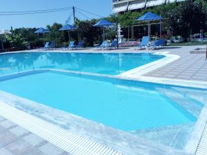 uma grande piscina com água azul em Brati - Arcoudi Hotel em Arkoudi