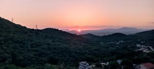 um pôr-do-sol sobre um vale montanhoso com árvores em Habitación Albergue en Parque Natural em Sant Pere de Reixac