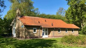 stary dom z pomarańczowym dachem na dziedzińcu w obiekcie Vakantiehuis De Branding, slechts 2 minuten van Strand en Zee! w mieście Vrouwenpolder