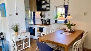 een keuken met een houten tafel en een eetkamer bij Vakantiehuis De Branding, slechts 2 minuten van Strand en Zee! in Vrouwenpolder