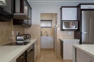 a small kitchen with a sink and a microwave at Ballito Manor View 503 - With Generator in Ballito