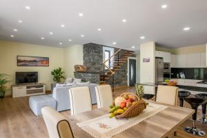 eine Küche und ein Wohnzimmer mit einem Tisch und einer Obstschale in der Unterkunft Villa Teresa by Atlantic Holiday in São Vicente