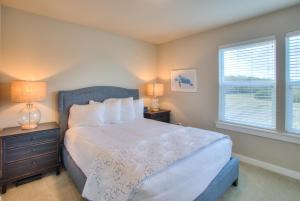 ein Schlafzimmer mit einem Bett und zwei Lampen und einem Fenster in der Unterkunft Sandy Feet And Doggy Treats in Ocean Shores