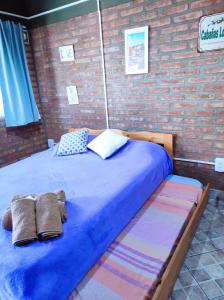 ein großes Bett in einem Zimmer mit Ziegelwand in der Unterkunft Cabañas Los Lúpulos in El Bolsón