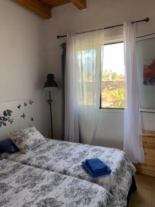 1 dormitorio con 2 camas y ventana en joy en Lajares