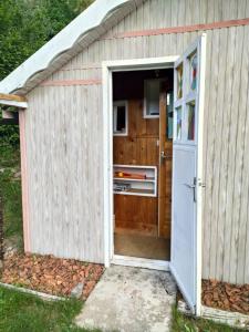 otwarte drzwi małej szopy z kuchenką w obiekcie Au garni w mieście Thiéfosse