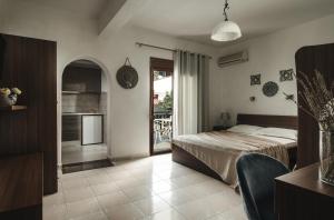 a bedroom with a bed and a kitchen with a balcony at Tsamakdas House in Toroni