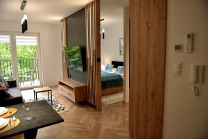 a bedroom with a bed and a living room at Apartament SunPark in Przemyśl