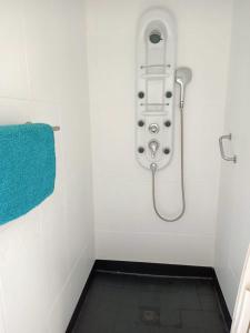 La salle de bains est pourvue d'une douche et d'une serviette bleue. dans l'établissement Ocean Surf Suite, à Playa del Hombre