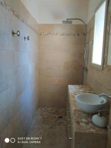 a bathroom with a sink and a shower at Proche Uzès petit gîte avec grande cuisine d'été et piscine in Saint-Siffret