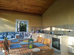 a living room with a table and a kitchen at Proche Uzès petit gîte avec grande cuisine d'été et piscine in Saint-Siffret