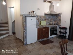 a kitchen with a white refrigerator and a stove at Casa Angelene in Vitorchiano