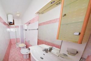 a bathroom with a sink and a toilet and a mirror at SOLEMAREPONZA Casa il Bacio del Sole in Ponza +8 photos