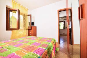 a bedroom with a colorful bed and a mirror at SOLEMAREPONZA Casa il Bacio del Sole in Ponza